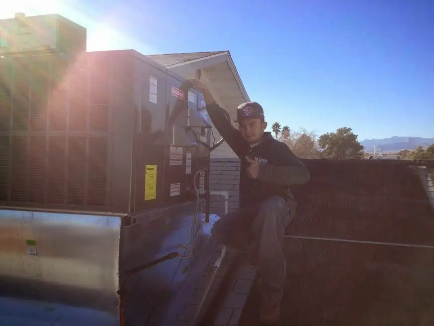 HVAC technician performing Boiler Repair on a rooftop unit in Davis